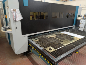 laser cutting machine with pull out drawer showing a laser cut brass sheet